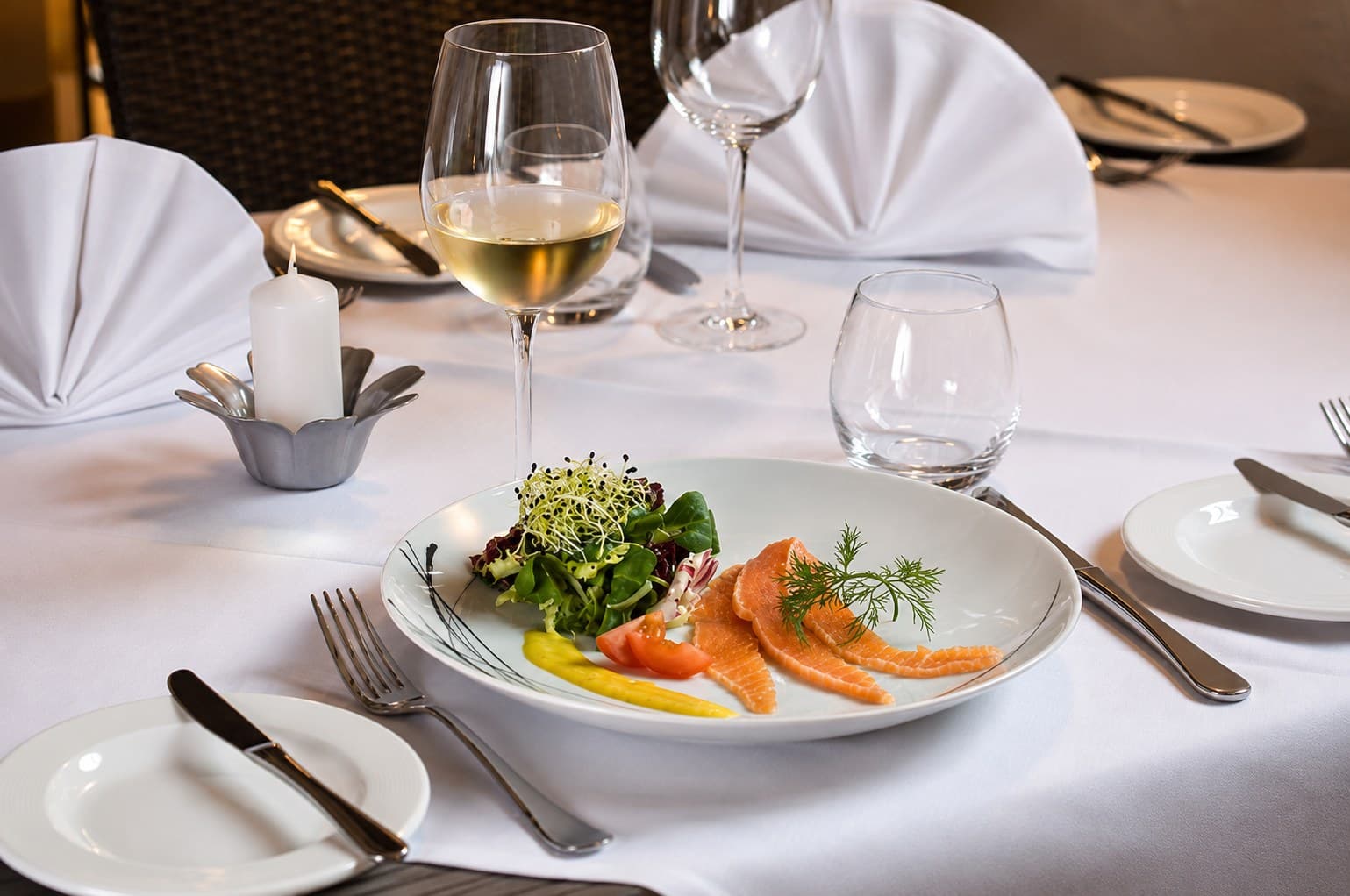 Gebeizter Lachs mit Blattsalat, Sprossen und Dill auf gedecktem Tisch